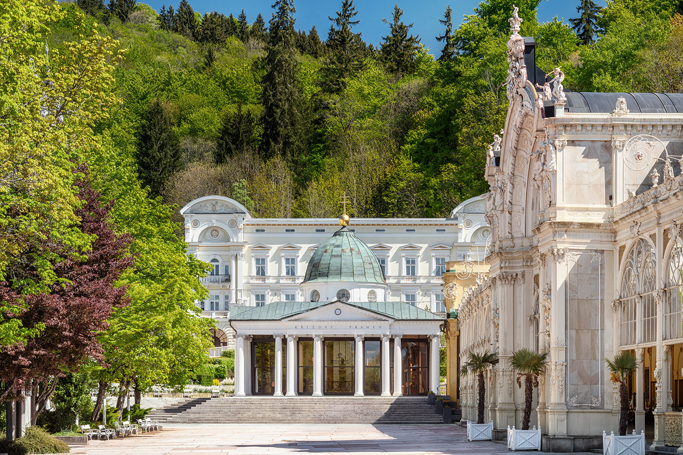 Pavilon Křížového pramene a Hlavní kolonáda mezi jarně olistěnými stromy