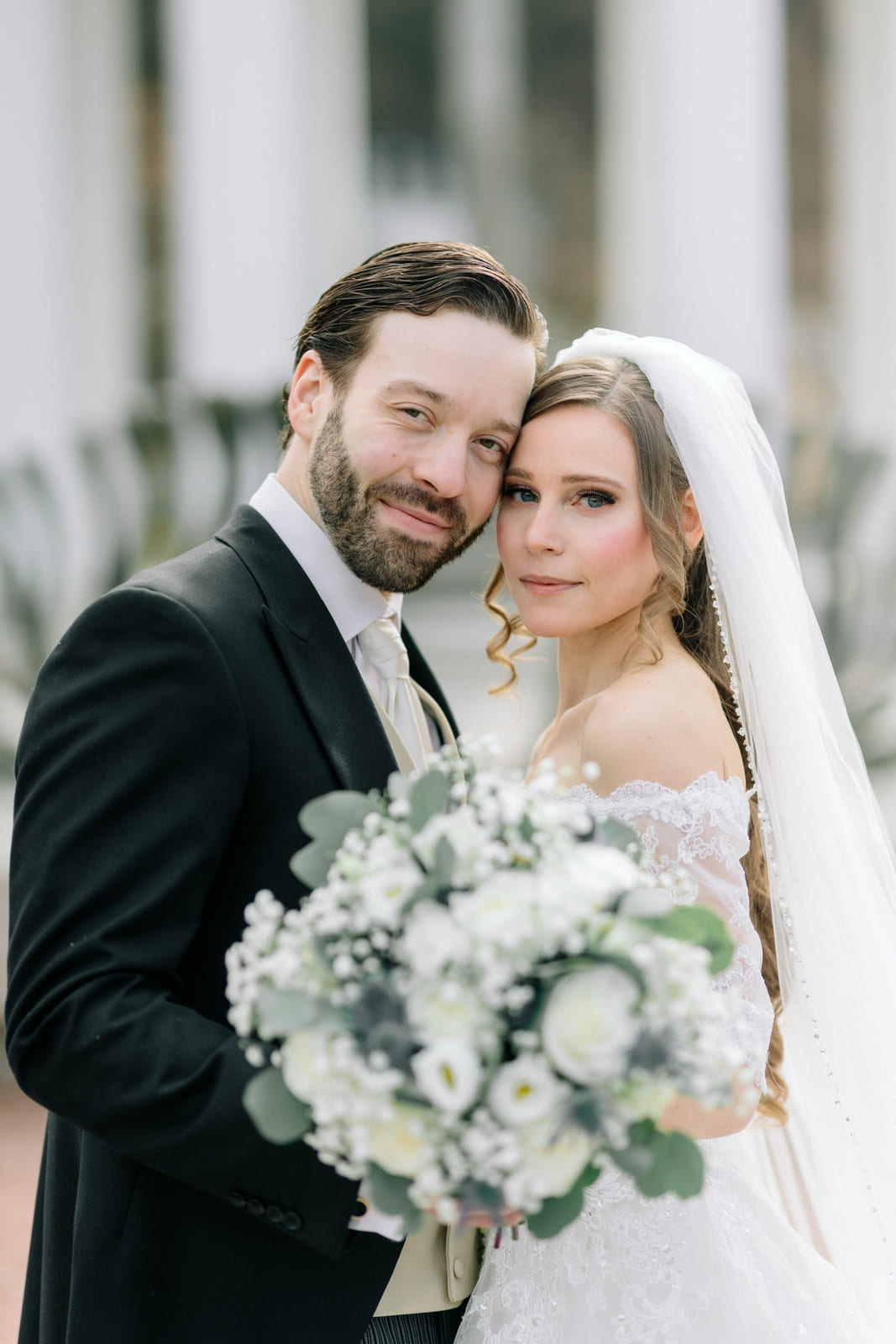 Porträt des Brautpaars mit einem Strauß weißer Rosen