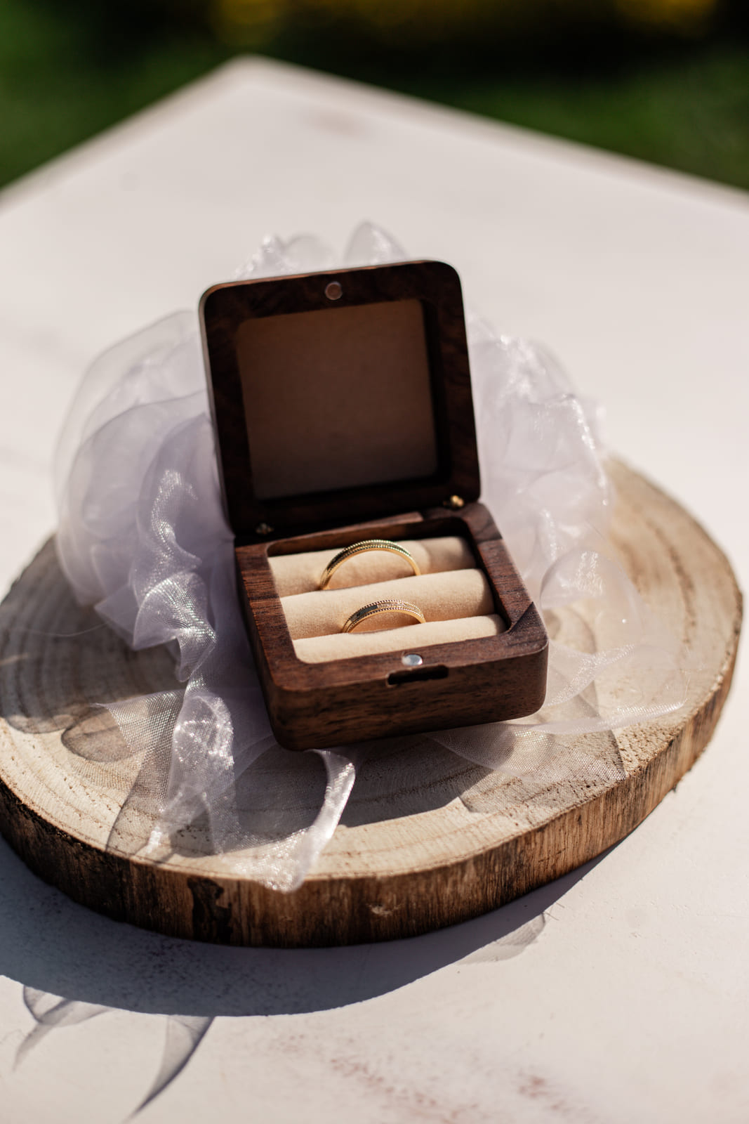 Eheringe in einer Holzschatulle auf der Hochzeitstafel